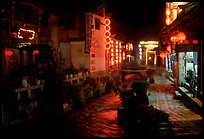 Red lanterns reflected in a canal at night. Lijiang, Yunnan, China