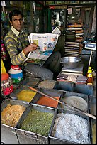 Man with newspaper selling grains, Sardar Market. Jodhpur, Rajasthan, India