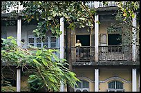 Facade with balconies and man reading. Mumbai, Maharashtra, India