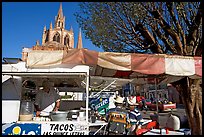 Taco stand on town plaza with cathedral in background. Mexico