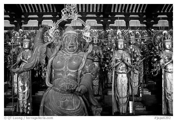 Some of the 1001 statues of the thousand-armed Kannon (buddhist goddess of mercy), Sanjusangen-do Temple. Kyoto, Japan (black and white)