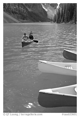 Colorful canoes and conoeists on Moraine Lake. Banff National Park, Canadian Rockies, Alberta, Canada (black and white)