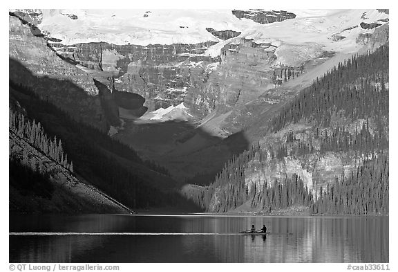 Rowers on Lake Louise, below Victoria Glacier, early morning. Banff National Park, Canadian Rockies, Alberta, Canada