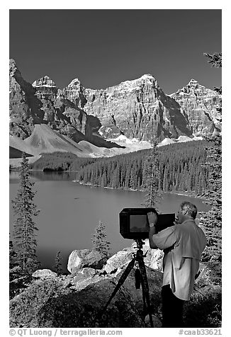 Photographer operating a 8x10 view camera at Moraine Lake. Banff National Park, Canadian Rockies, Alberta, Canada (black and white)