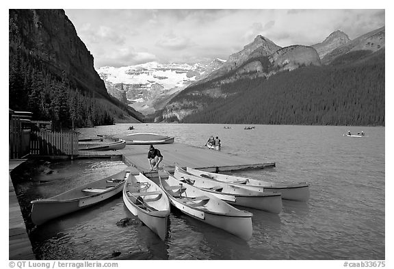 Red canoes at boat dock, Lake Louise, morning. Banff National Park, Canadian Rockies, Alberta, Canada (black and white)