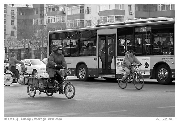 Tricyle, bicycles and bus on street. Beijing, China (black and white)