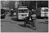 Tricycle and taxi on street. Beijing, China (black and white)