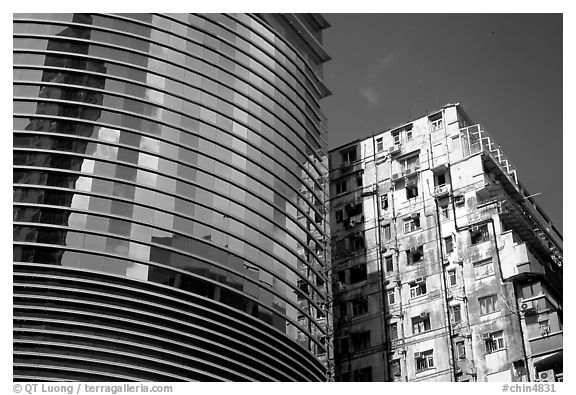 Glass building aside an old building, Kowloon. Hong-Kong, China (black and white)