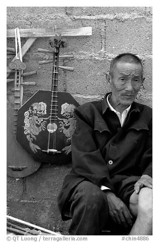 Man selling musical instruments. Shaping, Yunnan, China (black and white)