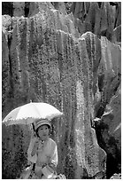 Woman from the Sani branch of the Yi tribespeople with a sun unbrella at the Stone Forest. Shilin, Yunnan, China (black and white)