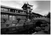 Kegong tower (memorial archway of imperial exam) reflected in canal, sunrise. Lijiang, Yunnan, China ( black and white)