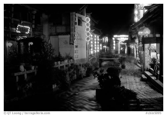 Red lanterns reflected in a canal at night. Lijiang, Yunnan, China (black and white)