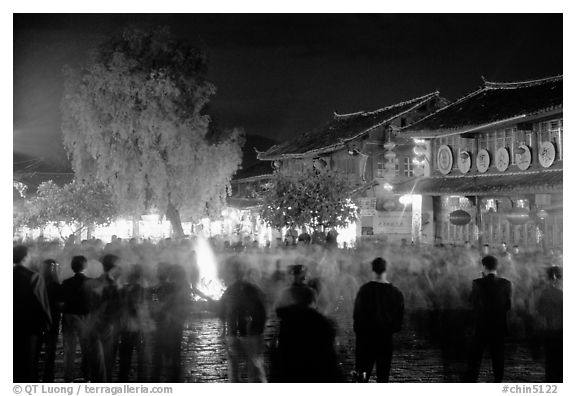 Celebration around a fire in Square Street by night. Lijiang, Yunnan, China (black and white)