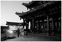 Pilgrim prays in the Jinding Si (Golden Summit) temple at dusk. Emei Shan, Sichuan, China ( black and white)