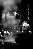 Pilgrim offering big incense stick. Emei Shan, Sichuan, China (black and white)