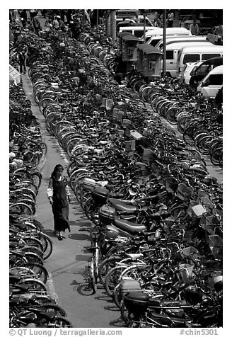 Woman walking in a bicycle parking lot. Chengdu, Sichuan, China (black and white)