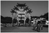 Villagers heading towrds fields, and Hu Wenguang Memorial Arch. Xidi Village, Anhui, China ( black and white)