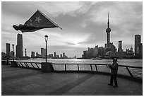 Man flying kite with Chinese flag attached on line, the Bund. Shanghai, China ( black and white)