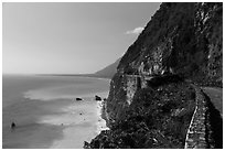 Road atop steep see cliffs overlooking ocean. Taroko National Park, Taiwan (black and white)