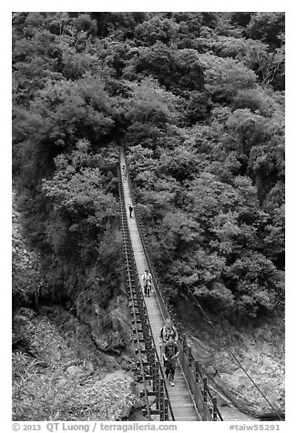 Hikers cross suspension bridge. Taroko National Park, Taiwan (black and white)