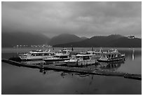 Pier with distant lights of Itashao Village and Syuanzang Temple at dawn. Sun Moon Lake, Taiwan ( black and white)