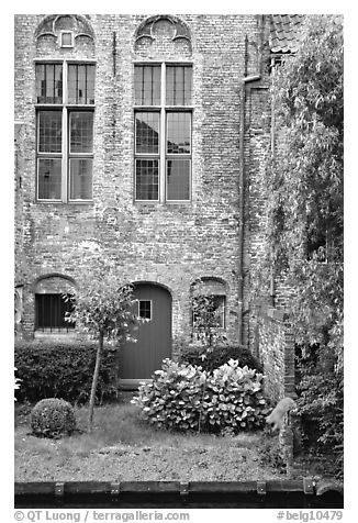 Brick house with small garden by the canal. Bruges, Belgium (black and white)