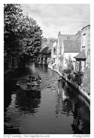 Boat on a canal lined with houses and trees. Bruges, Belgium (black and white)