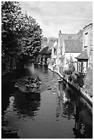 Boat on a canal lined with houses and trees. Bruges, Belgium ( black and white)
