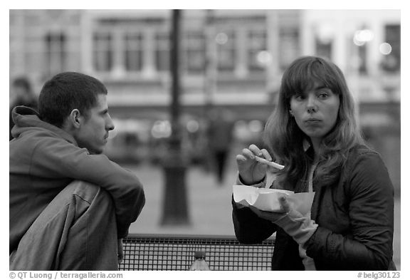 Young woman eating fries, Markt. Bruges, Belgium (black and white)