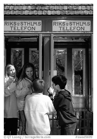 Swedish kids in a phone booth. Stockholm, Sweden (black and white)