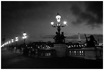 Lamps on Pont Alexandre III and Eiffel Tower at night. Paris, France ( black and white)
