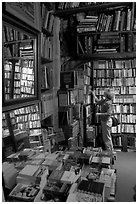 Picking-up a book in Shakespeare and Co bookstore. Quartier Latin, Paris, France (black and white)