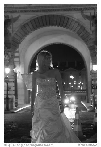 Woman in bridal gown in front of the Louvre by night. Paris, France