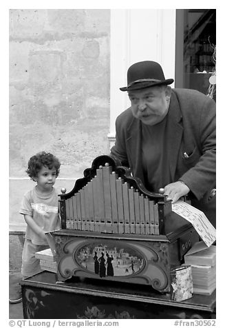 Barrel organ player and kid. Quartier Latin, Paris, France (black and white)