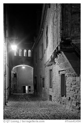 Cobblestone street by night inside medieval city. Carcassonne, France (black and white)