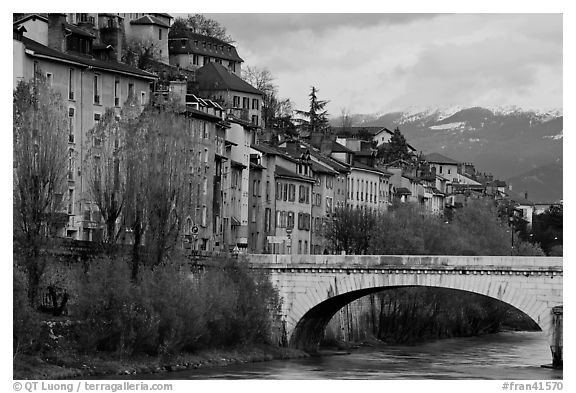 Stone bridge, houses, and snowy mountains. Grenoble, France (black and white)