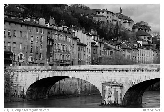 Stone bridge and brightly painted riverside townhouses. Grenoble, France (black and white)