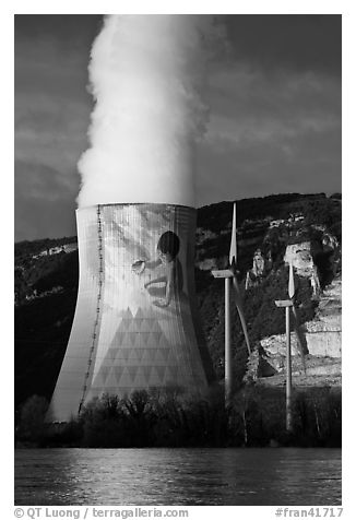 Cooling tower of nuclear power plant with ecology-themed art by Jean-Marie Pierret, and windmill. Provence, France (black and white)