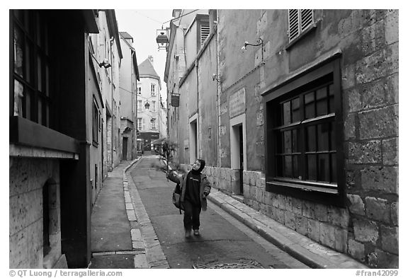Boy walking in narrow street, Chartres. France (black and white)
