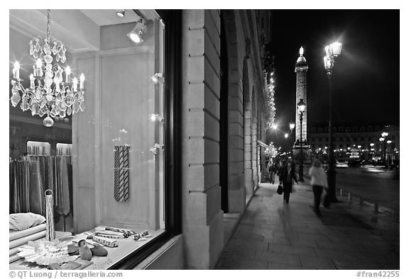 Luxury storefront and Place Vendome column by night. Paris, France