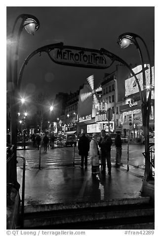 Art deco subway entrance and Moulin Rouge by night. Paris, France (black and white)