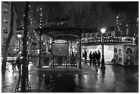 Square with subway entrance and carousel by night. Paris, France (black and white)