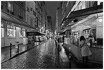 Woman buying food on street at night. Quartier Latin, Paris, France (black and white)