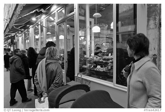 Customers wait in line in front of a popular bakery. Paris, France (black and white)
