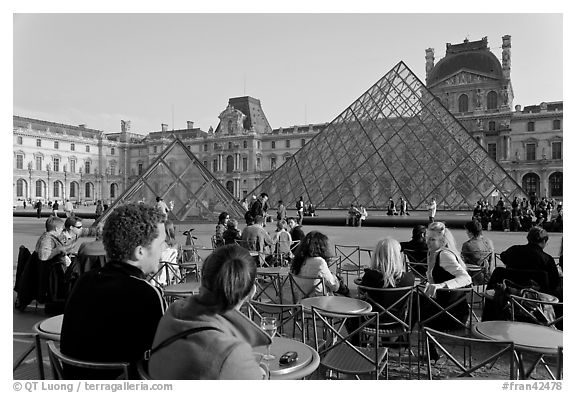 Cafe terrace in the Louvre main courtyard with glass pyramid. Paris, France (black and white)