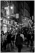 Busy pedestrian street at night. Quartier Latin, Paris, France (black and white)