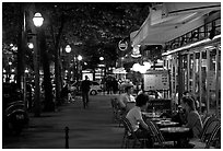 Outdoor cafe terrace on the Grands Boulevards at night. Paris, France (black and white)
