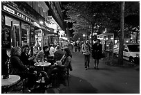 Cafe bar on sidewalk of a Grand Boulevard at night. Paris, France (black and white)