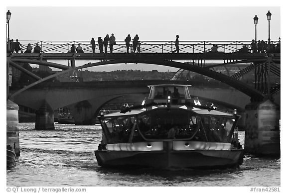 Tour boat below Pont des Arts at sunset. Paris, France (black and white)