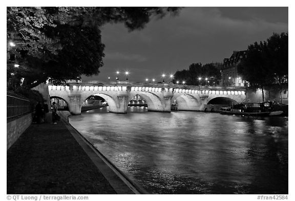 Quay, Seine River, and Pont-Neuf at night. Paris, France (black and white)